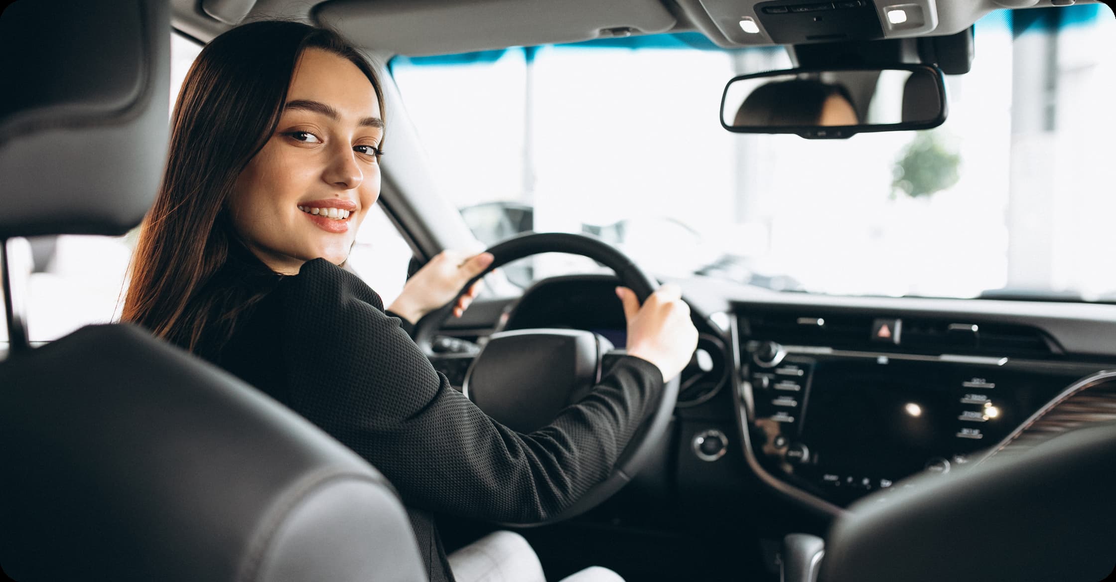 Passenger smiling from the driver seat of a car